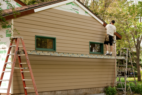 A man sides a home with Hardie Board