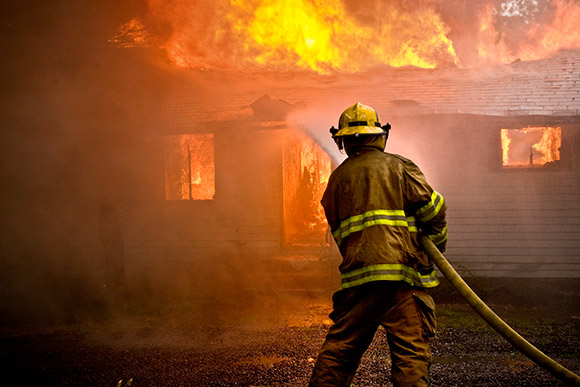 Firefighter putting out a house fire