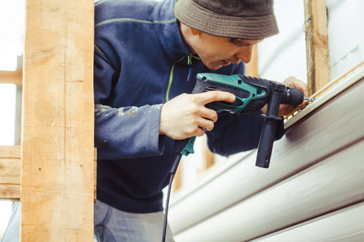 worker-installs-panels-beige-siding