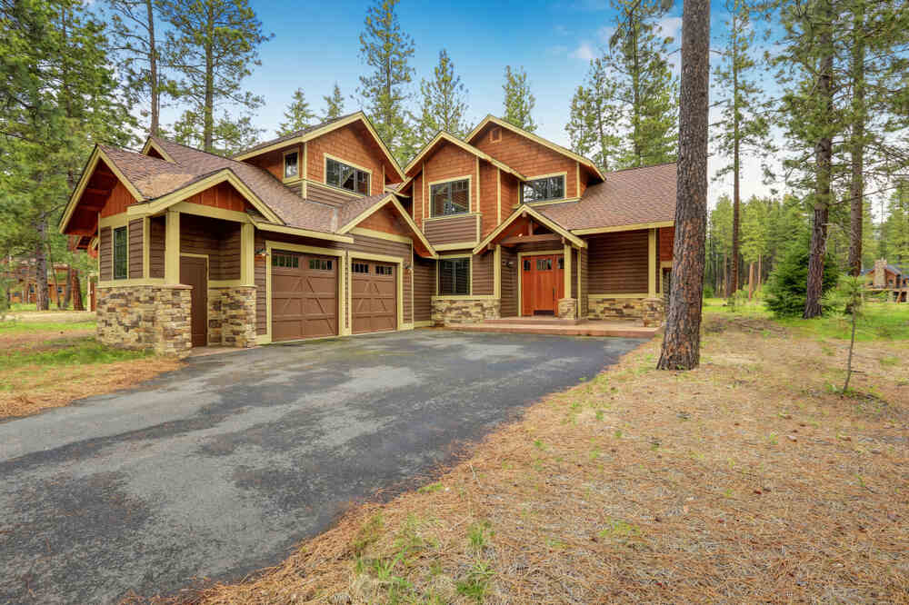 A house with wood siding surrounded by trees.