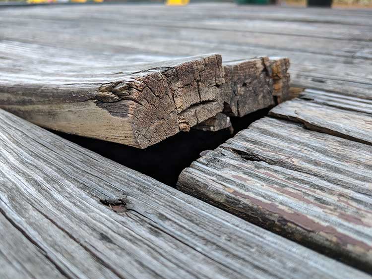 Warped wooden deck floor board